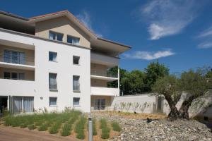 a white building with a tree in front of it at Domitys Les Clés d'Or in Orthez