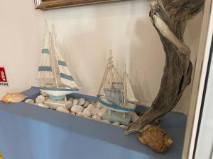 une étagère avec des bateaux et des rochers sur un mur dans l'établissement Stella Alpina, à Rimini