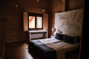 Un dormitorio con una cama con una pared con animales. en Трипільське Сонце, en Podgortsy