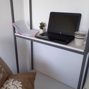 einen Laptop auf einem weißen Schreibtisch in der Unterkunft jazmin1 in Colonia del Sacramento