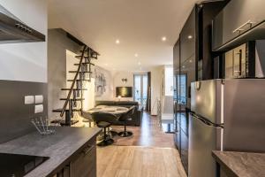 a kitchen with a refrigerator and a living room at Le grand duplex du lac in Veyrier-du-Lac