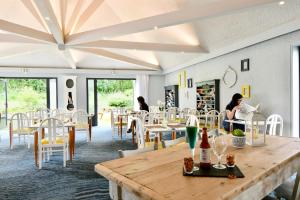 een restaurant met tafels en stoelen en mensen aan tafel bij Kyriad Lannion-Perros-Guirec in Lannion