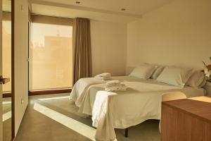 1 dormitorio con 1 cama grande y toallas. en Acíes Apartamentos Turísticos, en Cangas de Morrazo
