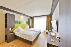 ein Hotelzimmer mit einem Bett und einem TV in der Unterkunft Mawell Resort in Langenburg