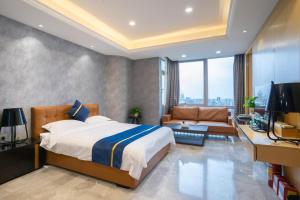 a bedroom with a bed and a couch and a television at Cloudy international apartment Beijing Rd A-mall in Guangzhou