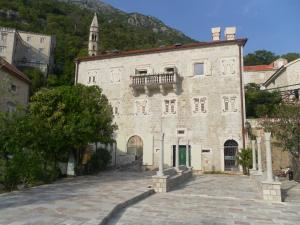 a large stone building with a balcony on top of it at Apartments David in Perast