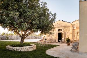een gebouw met een boom en een patio bij Baglio donna Concetta in Noto