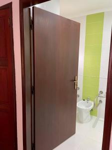 a door to a bathroom with a toilet and a sink at Hotel Rural A Coutada in Atouguia da Baleia