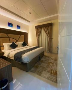 a bedroom with a large bed and a shower at منازل الطيف للوحدات السكنية in Al Madinah