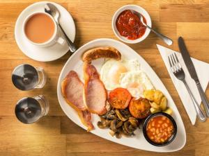 a plate of food with eggs and mushrooms and a cup of coffee at White Hart Hotel in St Austell