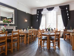 een eetkamer met houten tafels en stoelen bij White Hart Hotel in St Austell