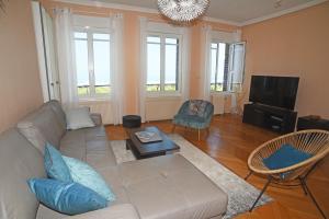 a living room with a couch and a tv at Les Pieds dans l'eau appartement vue mer in Dieppe +6 photos