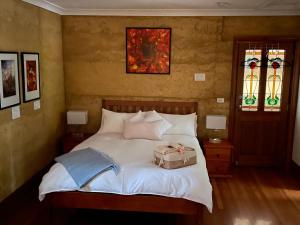 - une chambre avec un lit et une valise dans l'établissement Bundjil Studio, à Healesville