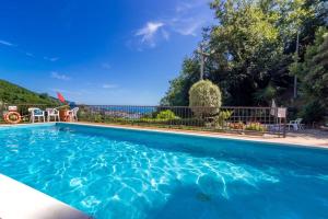 a swimming pool with blue water in a yard at Blue Lodge Lerici in San Terenzo