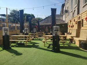 a group of wooden picnic tables in a yard at Uppercross House Hotel in Dublin