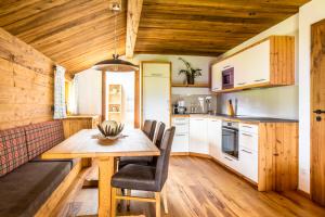 cocina con mesa de madera y sillas en Bio-Familienbauernhof Grubsteighof, en Sankt Koloman