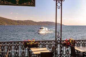 a boat in the water with tables and chairs at Hotel Garnì Riviera in Gargnano