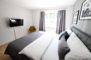 ein Schlafzimmer mit einem großen Bett und einem TV in der Unterkunft Armotti Apartments Friedheim in Bern