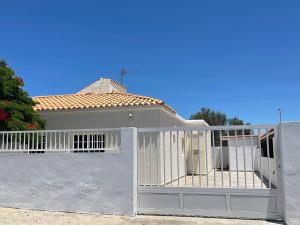 a white house with a gate in front of it at Casa Enamorado in Tarajalejo