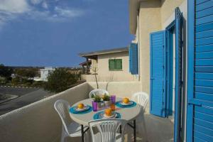 a table and chairs on the balcony of a house at Vitamin Sea Protaras in Protaras