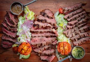 een bord vlees en groenten op een houten tafel bij Broom Hall Inn in Stratford-upon-Avon
