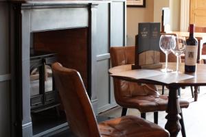a dining room with a table and a fireplace at Broom Hall Inn in Stratford-upon-Avon