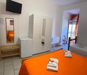 um quarto com uma cama com lençóis laranja e um espelho em B&B Franziska Mare em San Pietro in Bevagna
