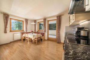 cocina y comedor con mesa y sillas en Ferienhaus Maria Steinröserl, en Pfelders