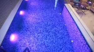 a swimming pool with purple lights in a building at Hilton Suites Lahore in Lahore