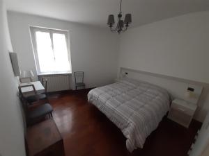 a white bedroom with a bed and a window at GRU HOME Cozy home very central,refined,5 beds,box in Grugliasco