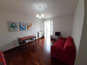 a living room with a red couch and a table at GRU HOME Cozy home very central,refined,5 beds,box in Grugliasco