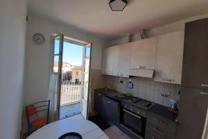 una piccola cucina con piano cottura e finestra di GRU HOME Cozy home very central,refined,5 beds,box a Grugliasco