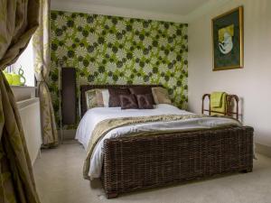 1 dormitorio con cama y pared verde en The Waters Edge Guest House en Stratford-upon-Avon