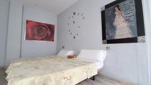 1 dormitorio con 1 cama y reloj en la pared en Hostal Martes Cáceres Plaza Mayor - Tercer piso SIN ascensor, en Cáceres