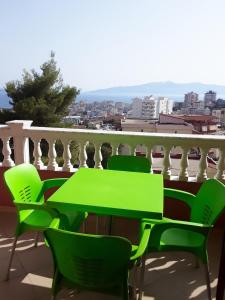 - Balcón con mesa verde y sillas en Vila Jakupi, en Sarandë