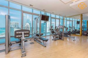 a gym with cardio equipment in a large room with windows at Keysplease Beautiful 2 B/R Beach Apt, Marina Trident Grand in Dubai