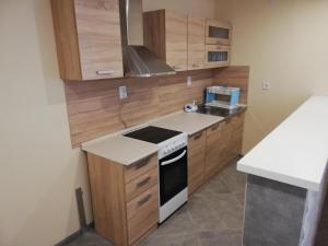a kitchen with wooden cabinets and a stove top oven at Дамяновата къща in Sapareva Banya