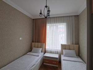 two beds in a room with a window at Abbasov's guest house-In Lahij in Lahıc