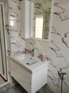 a bathroom with a white sink and a mirror at Abbasov's guest house-In Lahij in Lahıc