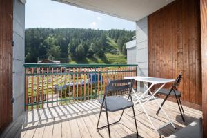 a balcony with a table and chairs and a view at Appartamento Smith Ruché - Affitti Brevi Italia in Bardonecchia