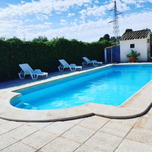 a swimming pool with blue water in a yard at Dehesa Vieja Casa Rural in Alarcón