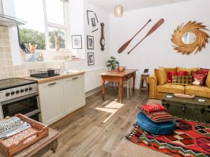 uma cozinha e sala de estar com um sofá e uma mesa em The Cottage em Penzance