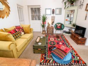 sala de estar con sofá y mesa en The Cottage en Penzance