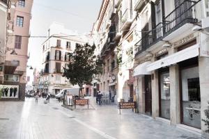 uma rua urbana com dois bancos e edifícios em Company 34 em Málaga