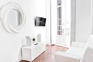a white living room with white furniture and a mirror at Company 34 in Málaga
