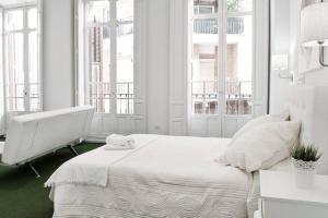 um quarto branco com uma cama grande e janelas em Company 34 em Málaga