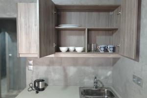 a kitchen counter with a sink and bowls on a shelf at Guest House Pauline in Kos