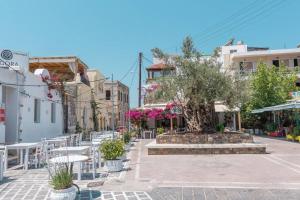 een straat met tafels en stoelen en een boom bij Guest House Pauline in Kos-stad