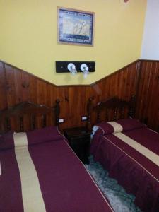 2 camas en una habitación con paneles de madera en Complejo Cabañas Foxes Frente al Lago en Villa del Dique