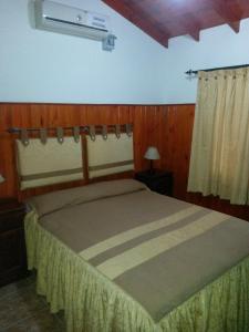 1 dormitorio con 1 cama grande en una habitación en Complejo Cabañas Foxes Frente al Lago en Villa del Dique